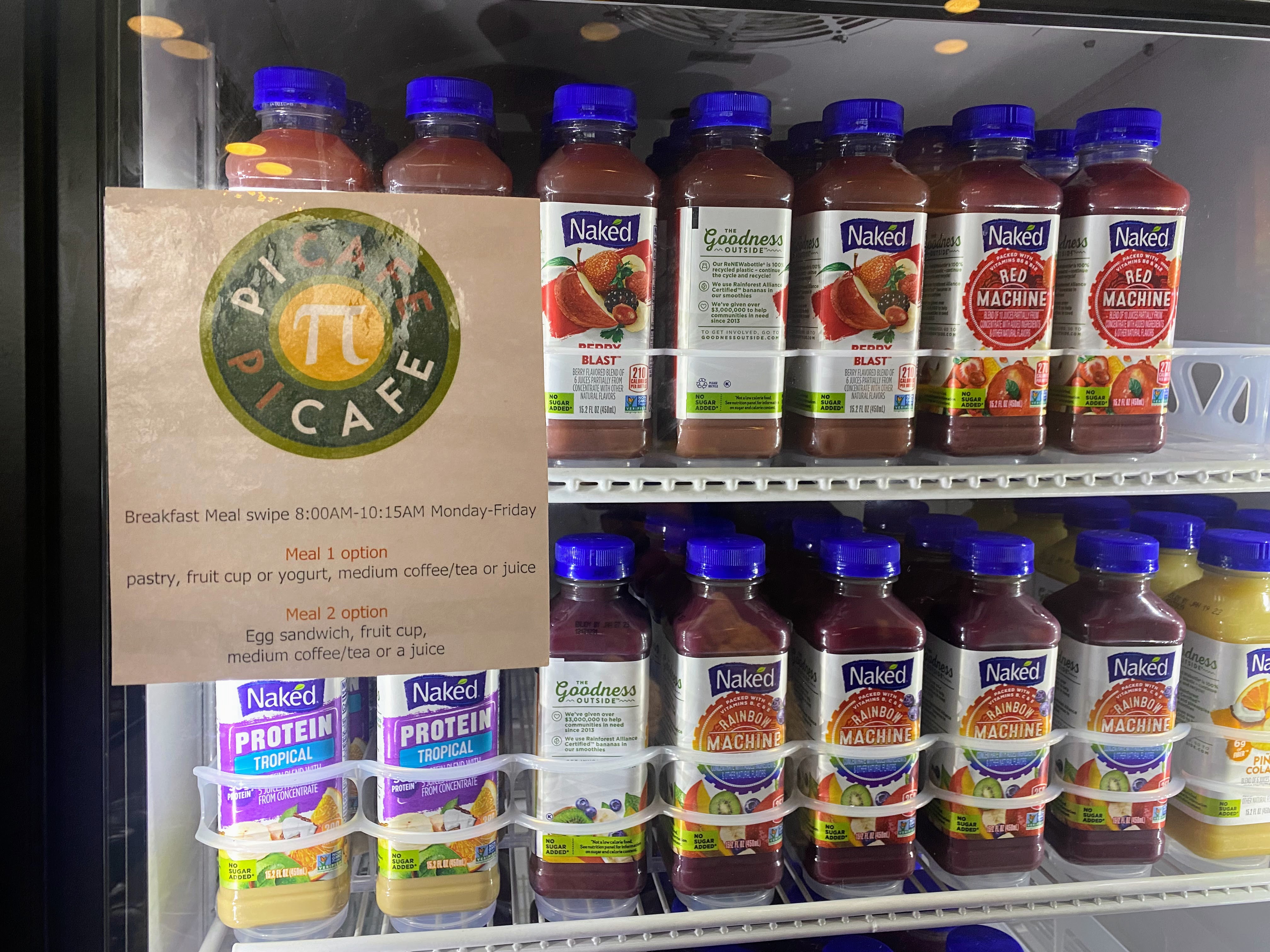 Photo of Wesleyan Pi Cafe fridge filled with various naked smoothie drinks and a pi cafe sign saying the different meal options for a meal