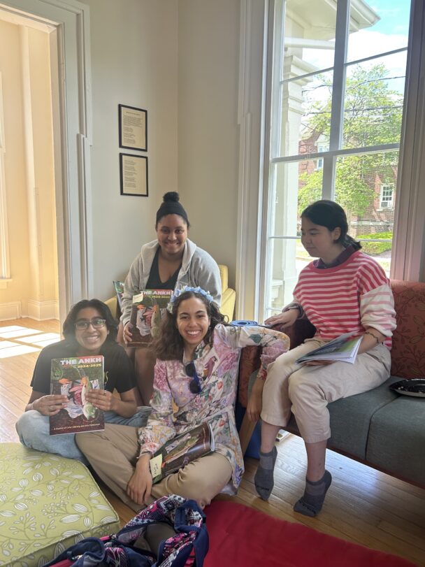 Four students sit on couch while holding Ankh magazine