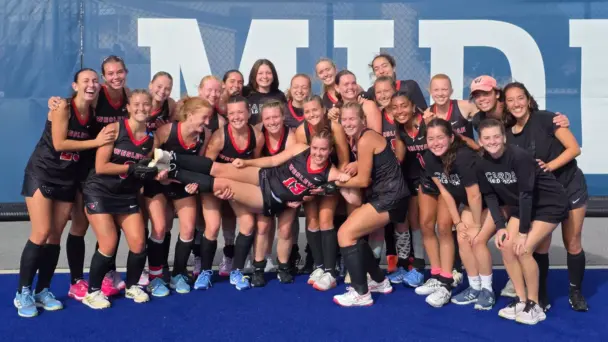 Woman's field hockey poses in front of blue background