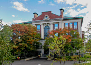Front of Allbritton, white building with red roofs and trees in front.