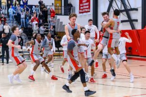 Basketball players from Wesleyan celebrate on the court